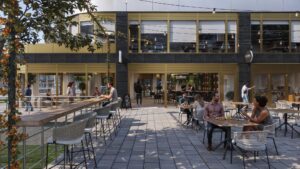 Terras met mensen die genieten van eten en drinken voor het gebouw aan de H.J.E. Wenckebachweg.